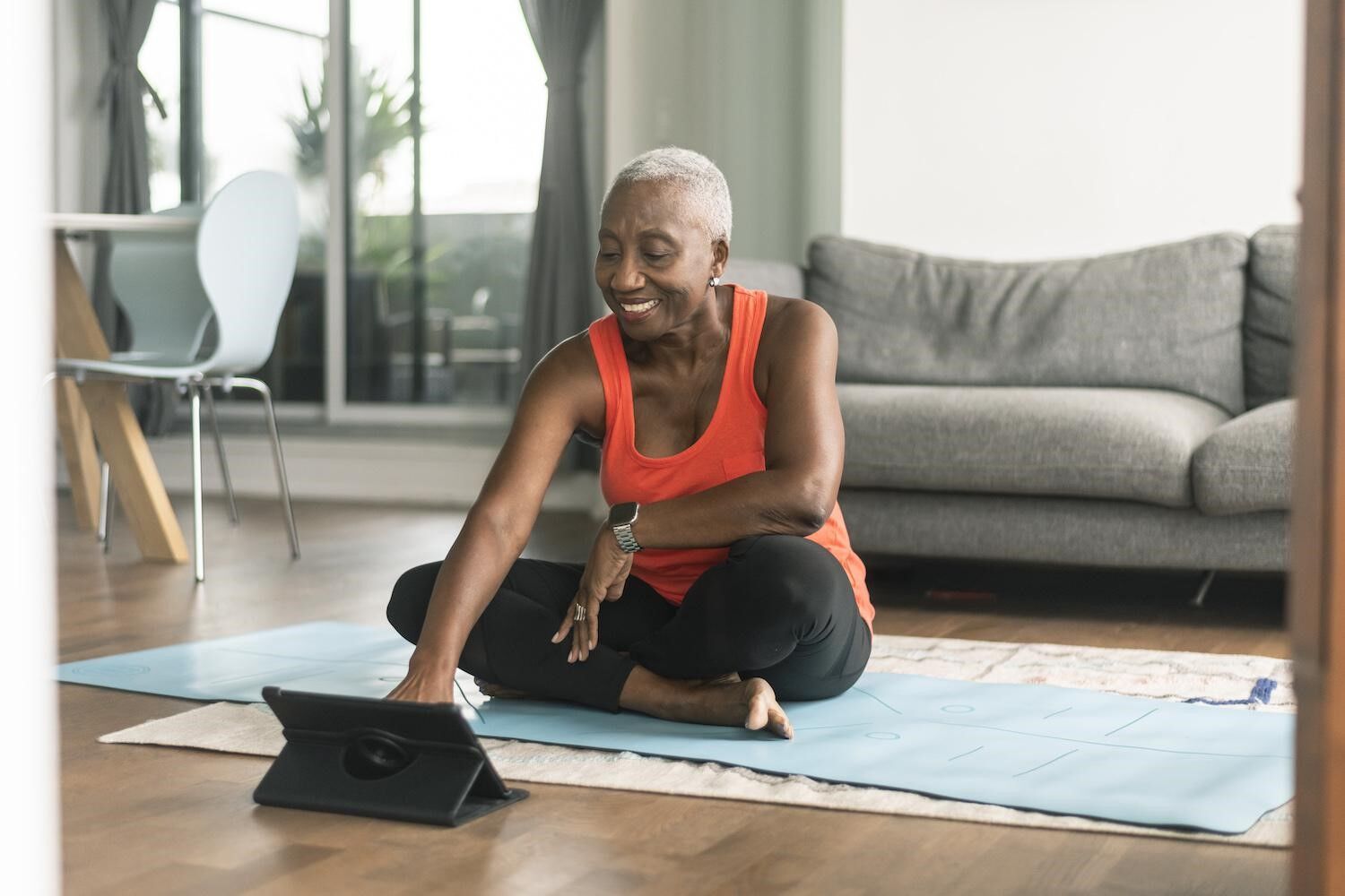 Woman sitting on yoga mat with tablet.jpg